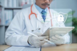 Médico usando tablet com ícone de escudo e login, ilustrando segurança de dados sobre proteção de dados em perícias médicas.