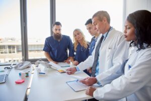 Equipe médica em reunião sobre glosa hospitalar.